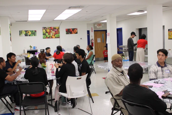 A photo of the participants sitting around a few tables in a room.