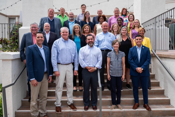 Members of the Hunt-Kean Leadership Fellows Cohort 9 pose smiling on a set of stairs.