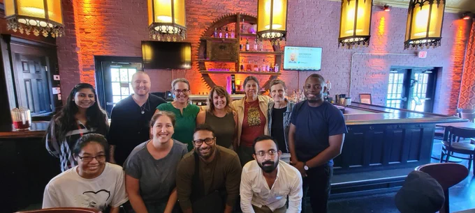 11 people standing in front of a bar