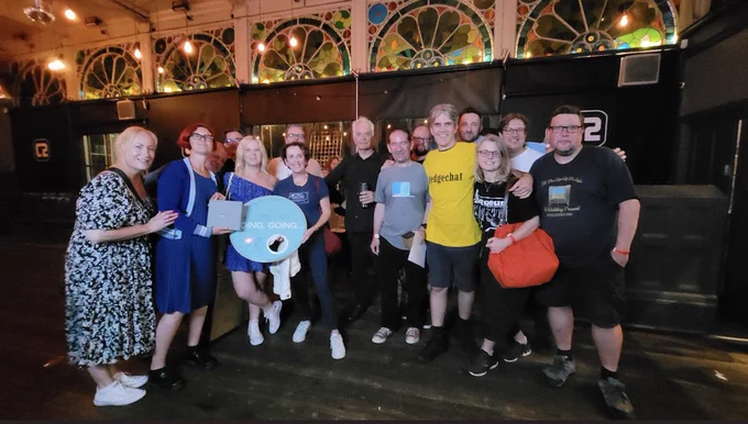 David Gedge in the middle of a bunch of beautiful Wedding Present fans. We are smiling and holding raffle prizes. At the Concorde 2 in Brighton.