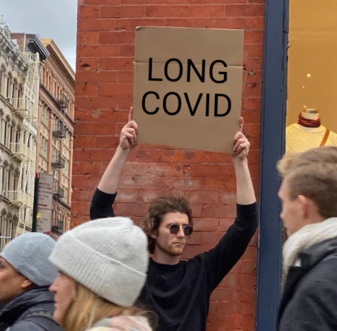 Man holding "LONG COVID" sign.