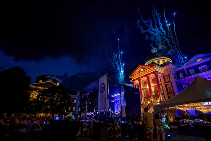 Christopher Newport Hall has blue fireworks going off over top while the Virginia Symphony Orchestra performs.