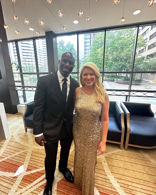 Terrell Davis and Amy Parsons pose together in a hotel lobby.