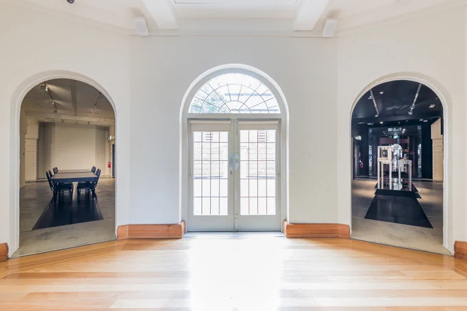 An interior shot of Grainger Museum featuring the iconic semicircle window flanked by two corridors: one leading left and the other to the right.