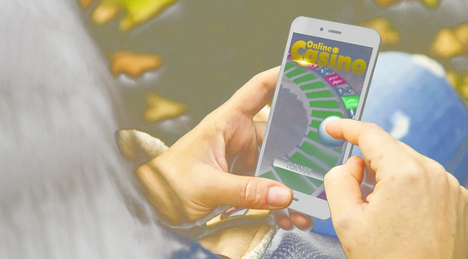 A woman plays an online casino game on her mobile phone.