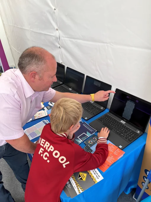 North Wales Police Cybercrime Team helping a child play CyberSprinters on a laptop