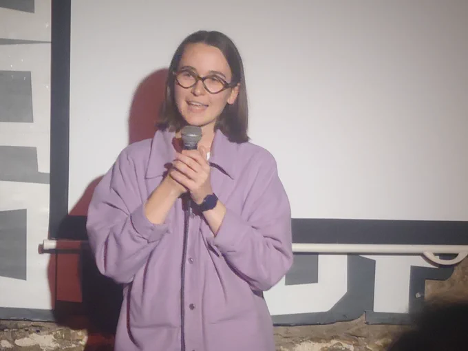 Imogen smiles, in a purple shirt