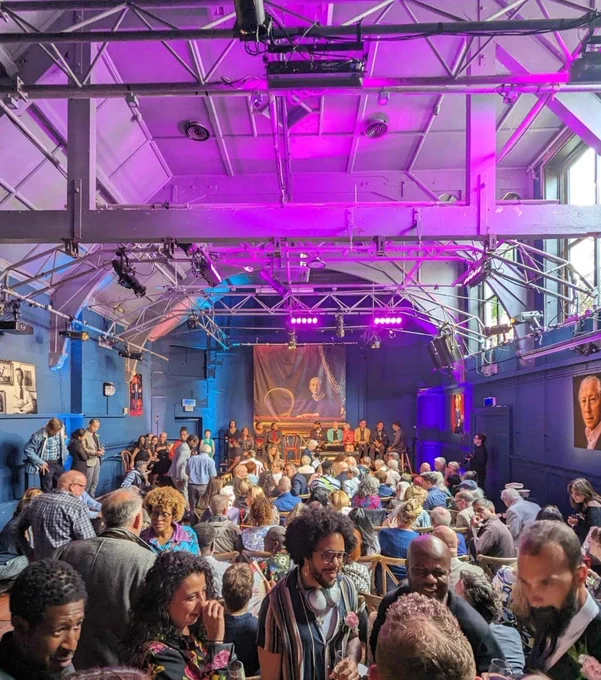 The auditorium bathed in pink and blue, full of people chatting before the start of the show. 