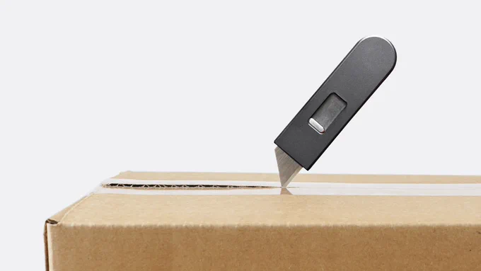 A Keen utility knife magically cutting open a cardboard box.