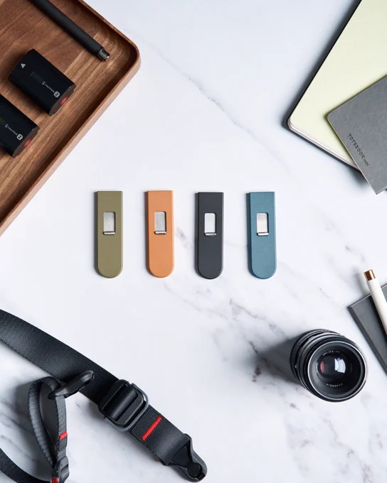 The four colors of Keen (green, orange, black, blue) laying on a marble table.