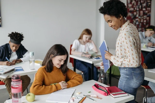 Image of an educator and student working together at a desk 