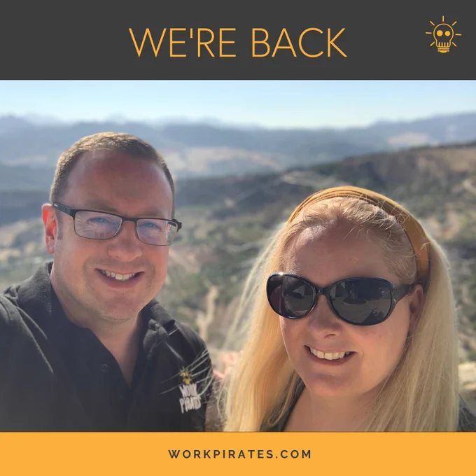 A photo of James and Michelle with a backdrop that is blurred of the hills around Ronda in Spain. Text shows “we’re back!”