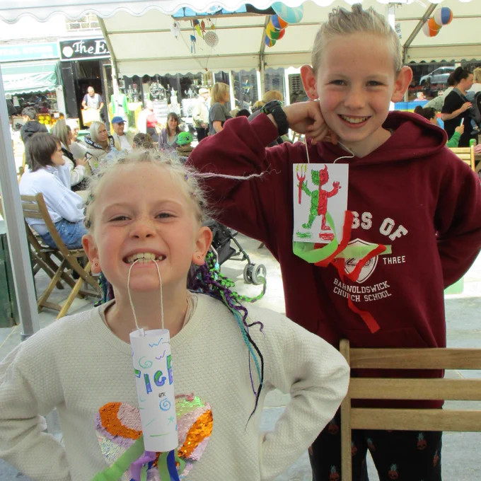 Two children with crafted windsocks