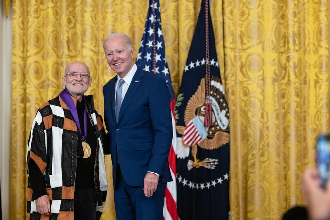 Antonio Martorell Cardona smiles with President Biden after receiving his National Medal of Arts