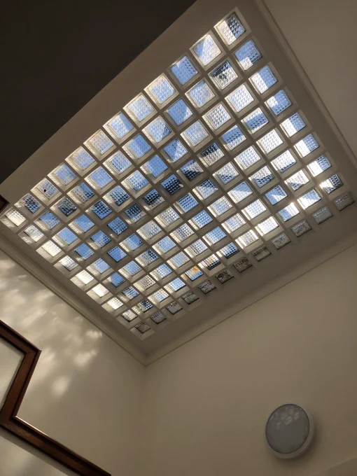 Sunlight streaming in through a glass block roof light above a stairwell 