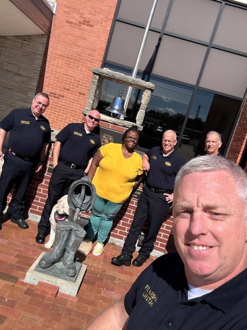 A group of employees smiling in front of TFD Headquarters.