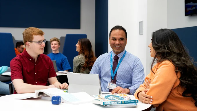 UCLan staff and students sitting around a table in a classroom setting