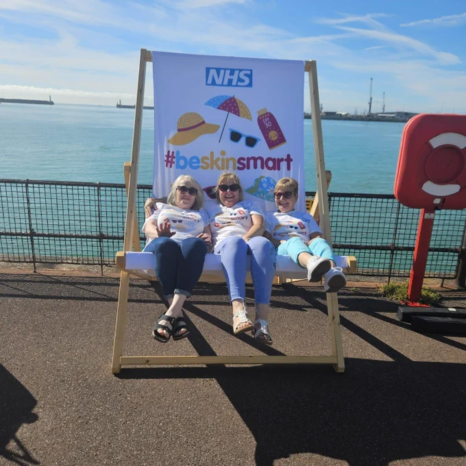 Our team posing for a photo in the giant #beskinsmart deck chair
