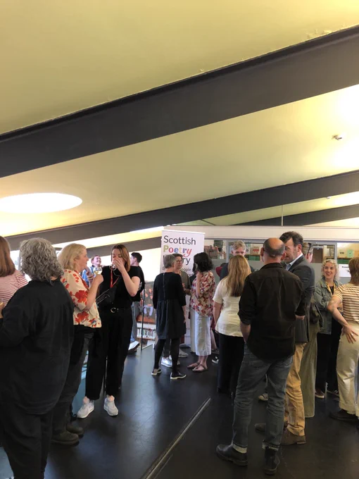 Decorative image: a mingling crowd of people in the Scottish poetry library