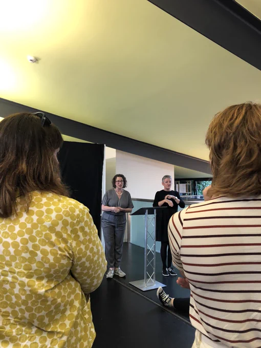 Decorative image: imaginate CEO Belinda giving a speech next to a BSL interpreter in the Scottish poetry library
