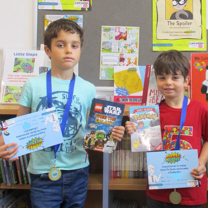 two boys with certificates and books