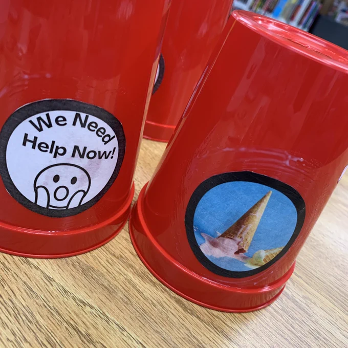 We need help now tags on red cups with a picture of a spilled ice cream cone.