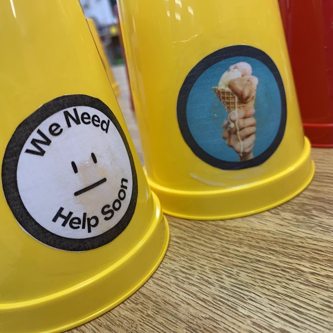 We need help soon tags on yellow cups along with a dripping ice cream cone.