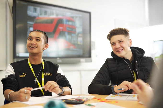Two students sat at a table smiling