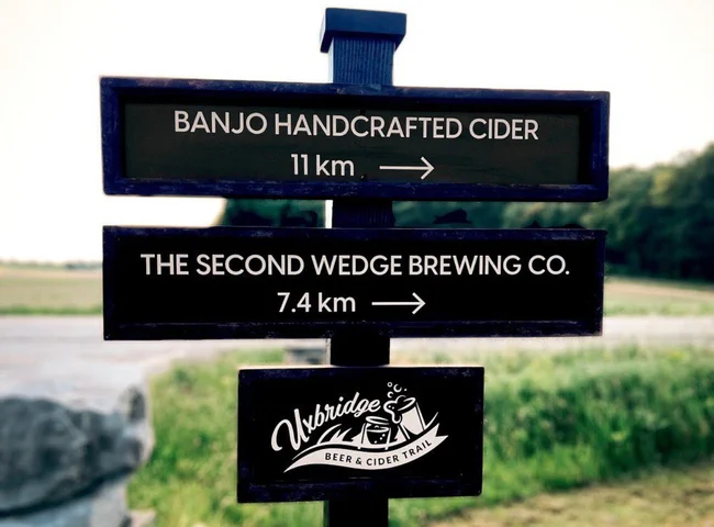 Sign that reads, “Uxbridge Beer and Cider Trail” with arrows pointing to Banjo Cider and The Second Wedge