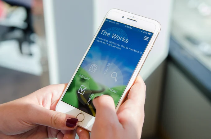 a close-up of an iphone with The Works app on the screen