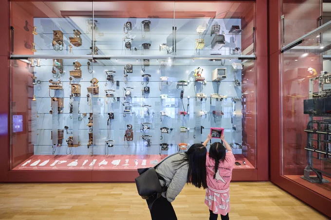 Mutter mit Kind vor einer Vitrine im MfK Berlin; Foto: © Yves Sucksdorff / MSPT / Museum für Kommunikation Berlin
