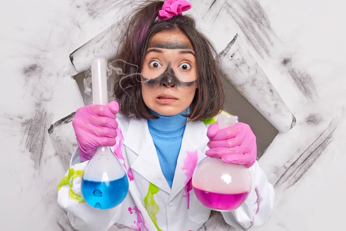 Eine Wissenschaftlerin hält zwei Laborglasgefäße, ein Experiment ist offenbar schief gelaufen