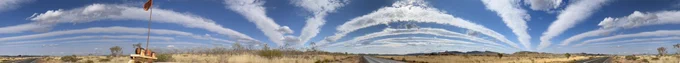 p360 degree anoramic view of cloud trains (blue sky, white lines of clouds, yellow ochre strip of land) in nyamal country, Australia