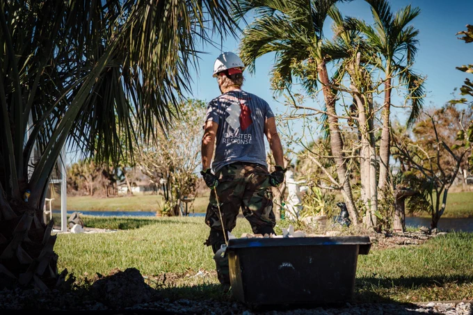 A Team Rubicon volunteer hauls debris following Hurricane Ian