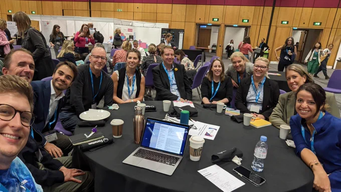 Selfie of Dan with people grouped around a table. 