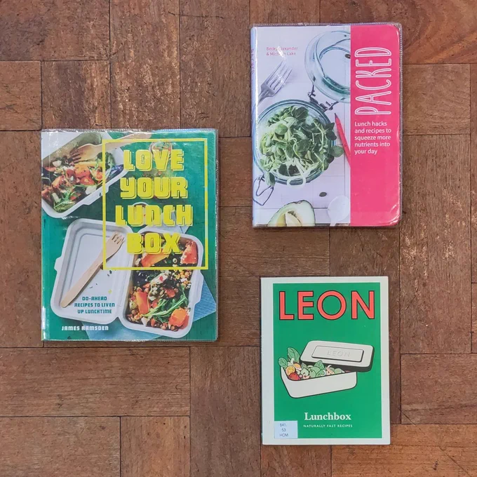 3 lunchbox recipe books on parquet floor: 'Love Your Lunch Box'; 'Packed'; 'Leon Lunchbox'