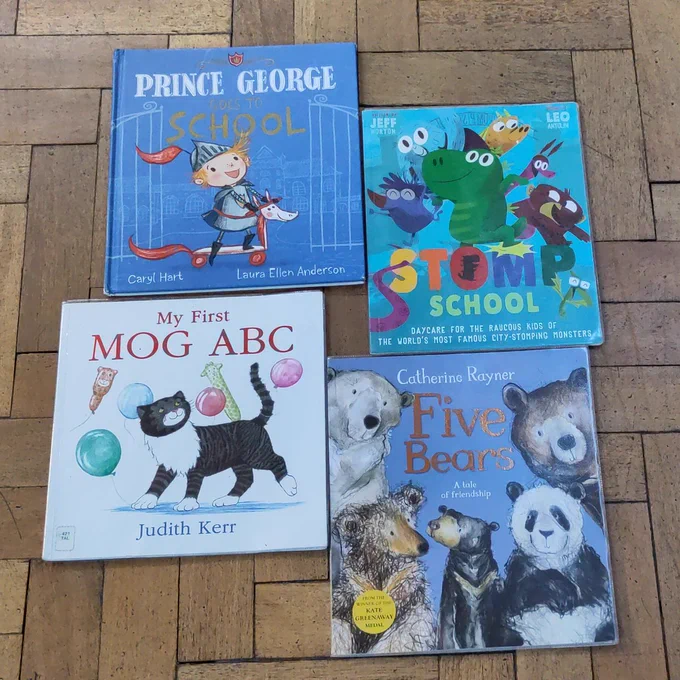 4 children's picture books displayed on a parquet floor. Clockwise from left: 'Prince George Goes To School'; 'Stomp School'; 'Five Bears'; 'My First Mog ABC'