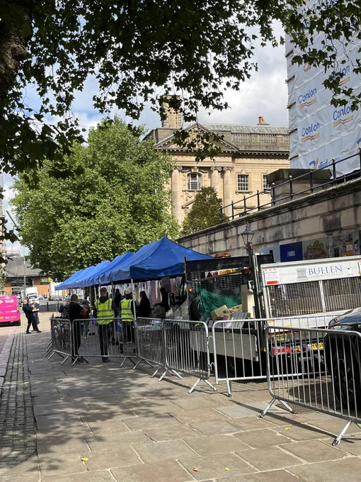 Gazebos on flag market with people in front