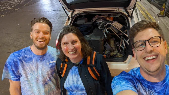 Selfie of the Forumm team with a car behind. 