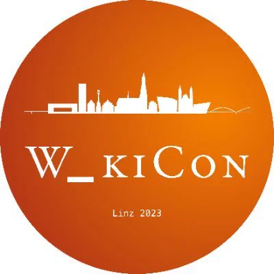 Logo der WikiCon Konferenz - weisse Schrift und Stadtsilhouette auf orangem Grund