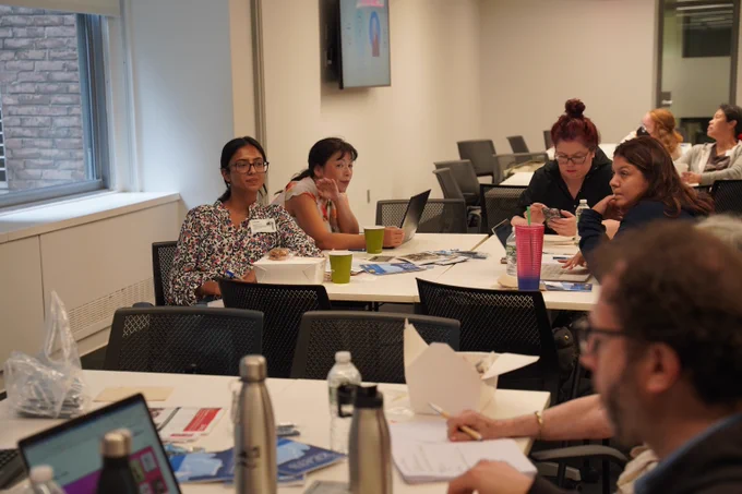 This photo shows a room full of new librarians listening to a training session.