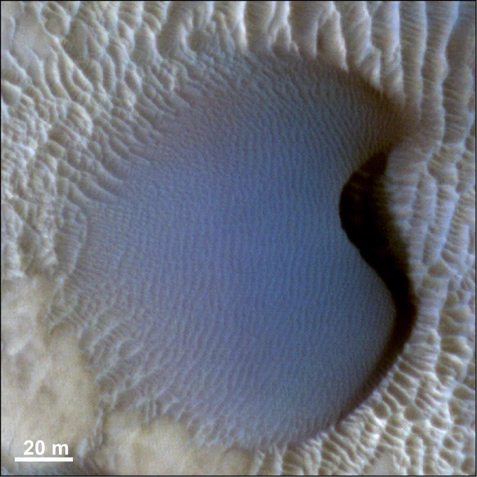 Barchan dune covered by dark-toned ripples with spacings between crests of ~3 m. These bedforms are migrating over brighter-toned transverse aeolian ridges (TARs). HiRISE image ESP_027864_2295_COLOR (credit: NASA/JPL/University of Arizona).