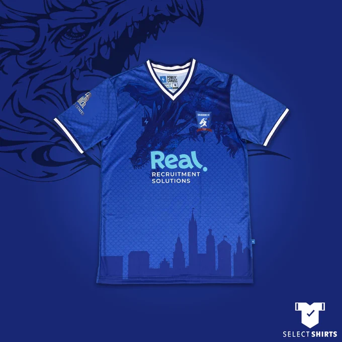 A stunning blue shirt featuring a dragon at the top and the Krakow skyline at the bottom. Sponsored by Real recruitment solutions