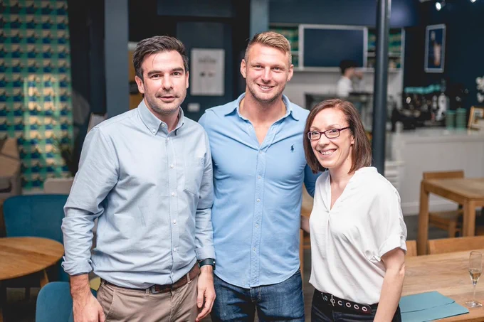 Image of three people stood smiling at the camera. Dan Biggar is stood in the middle. Either side of him, are members of staff from Creo Medical.