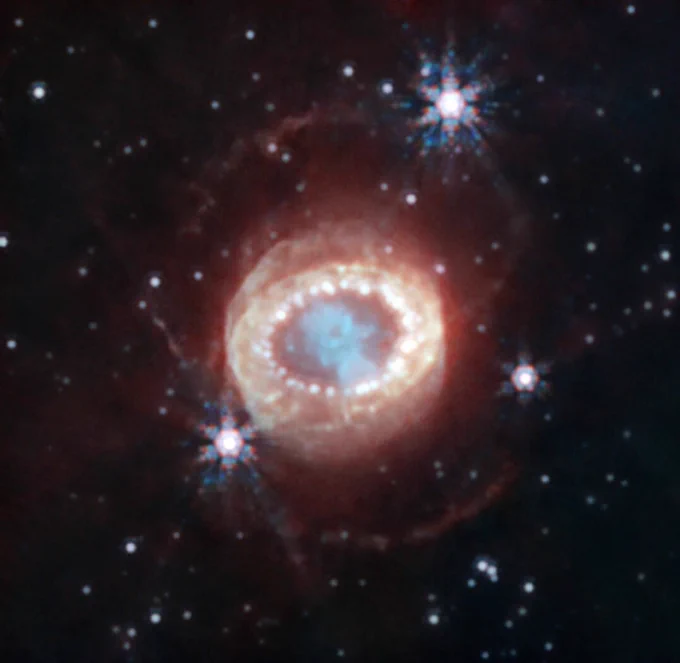 Red galaxy with a blue centre resembling an eye.