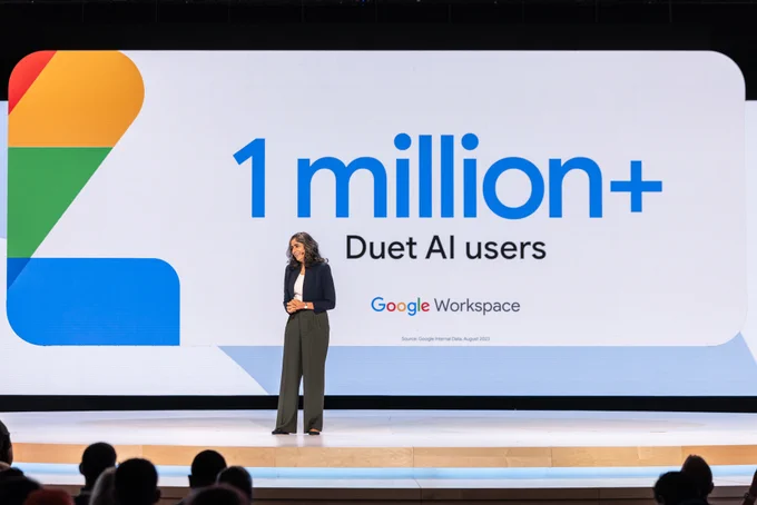 A photograph of Aparna Pappu on stage at Google Cloud Next. The image behind her reads '1 million  Duet AI users.'