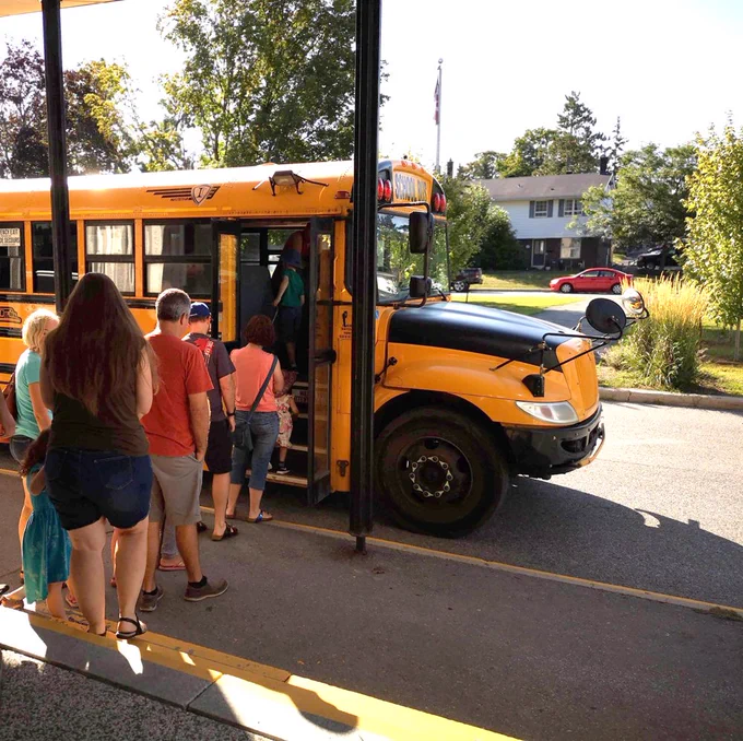 Children and parents preparing to get on a school bus