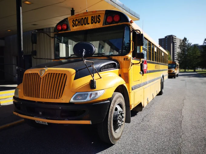 School bus parked in front of a school 