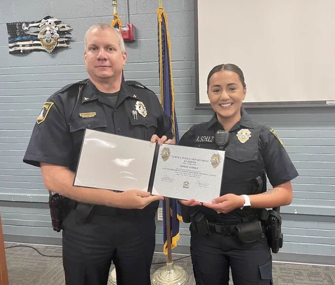 Chief Wheeles presents Officer Schulz her TPD Academy certificate of completion.