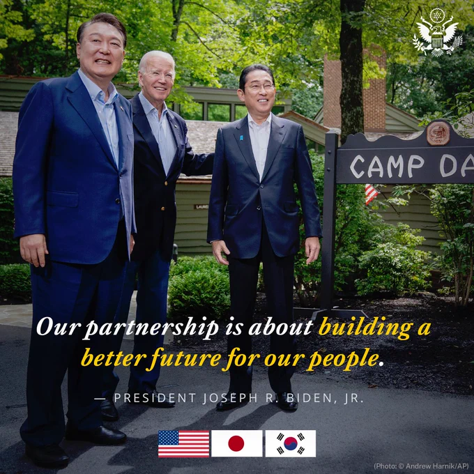 President Biden poses for a photo with President Yoon Suk Yeol of the Republic of Korea and Prime Minister Kishida Fumio of Japan at Camp David. U.S.-Japan-ROK flags are at bottom. Graphic Text: Our partnership is about building a better future for our people.” — President Joseph R. Biden, Jr.